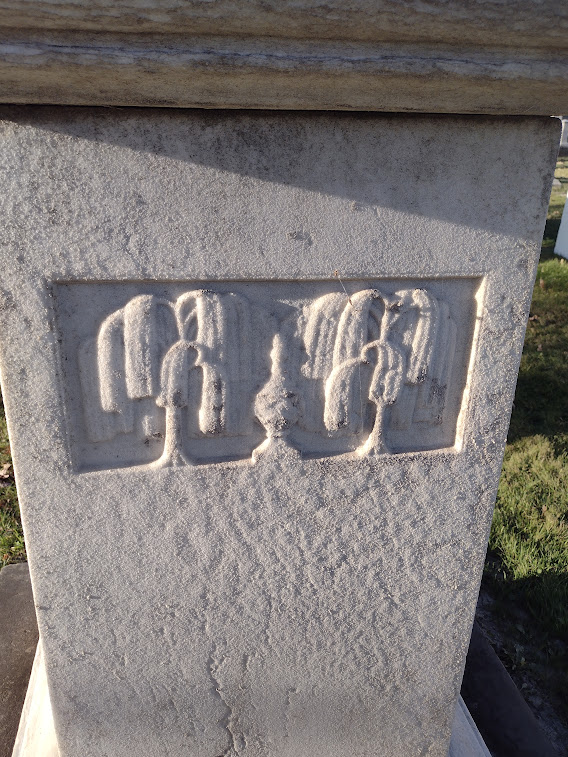 Stylized, more abstract weeping willow trees on a gravestone